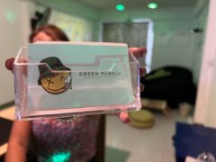 Green Family dispensary card holder in Pai, Mae Hong Son, Thailand, featuring cannabis smiley face logo.