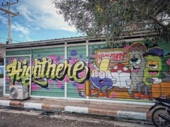 Exterior of HIGHTHERE dispensary, Hua Hin, Thailand, with colorful graffiti art.