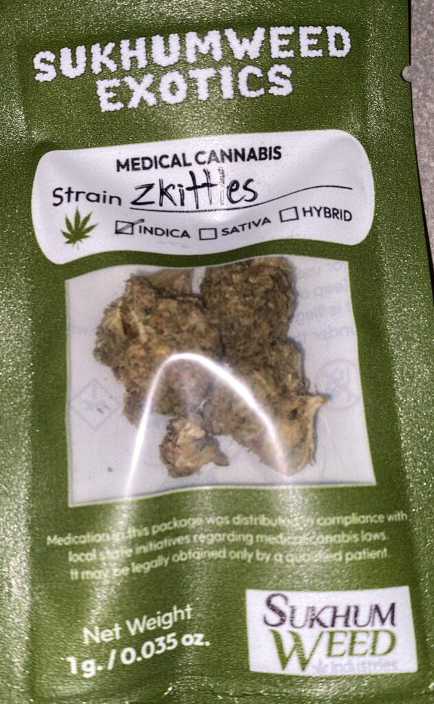 Cannabis buds in a clear plastic package, labeled 