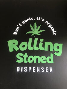 Black background with green cannabis leaf illustration and text: "Don't panic, it's organic", and "Rolling Stoned DISPENSER".