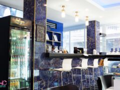 THC Bangkok cannabis cafe interior, Khlong Toei, Bangkok. Blue and gold bar-style seating with cannabis products.