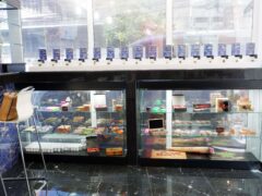 THC Bangkok cannabis shop interior, Khlong Toei, Bangkok. Displays of cannabis flower strains and RAW smoking accessories.