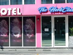 The Herb Club in Bangkok, Thailand; dispensary exterior with signs for sativa, hybrid, and indica cannabis.