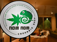 Nom Nom Cannabis shop sign, chameleon logo in Lat Phrao, Bangkok, selling cannabis flower and smoking accessories.