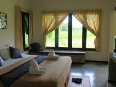Interior of a room at The Oriental Village Chiangmai resort, with window overlooking nature and cannabis friendly amenities.