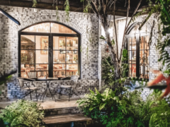 Exterior view of Gas9Exotics cannabis cafe in Ratchathewi, Bangkok, with garden seating area visible.