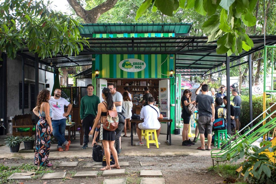 People gather outside a cafe called "Green Dog".