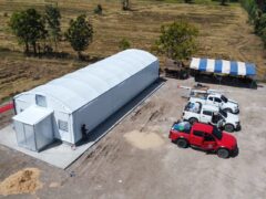Green Fingers Farmer cannabis farm in Buri Ram, Thailand, showing greenhouse, trucks, and outdoor area.