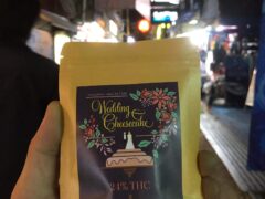 Hand holding a package of Wedding Cheesecake cannabis strain, 24% THC, at OG cafe in Ko Lanta Yai, Krabi, Thailand.