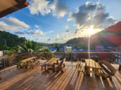Terrace with tables and benches overlooking Patong Bay, Phuket, Thailand. Denzpensary cafe location.