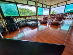 Interior of the cafe at Denzpensary in Patong, Phuket, with seating and view of Patong Bay.