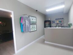 Interior of Kush Dee - Dispensary & Lounge in Pattaya, Thailand. Counter, cannabis strain posters, and lounge area visible. Weed shop.