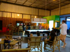 Interior of Cannasaur cannabis dispensary in Bang Lamung, Chon Buri, Thailand, showing people at bar and pool table.