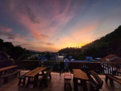 Balcony view at Denzpensary in Kathu, Phuket, Thailand, with sunset and seating.