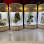 Four glass terrariums, each containing green plants, displayed in a row.