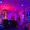 A dimly lit room with purple and pink lighting illuminating a dark reception desk.