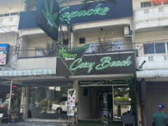 Exterior of Blow Cozy Beach dispensary in Pattaya City, Thailand, with neon sign and karaoke.