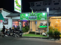 Exterior of Blow Livingroom cannabis shop in Pattaya City, Thailand, with sign, and motorcycles parked in front.