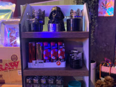 Smoking accessories for sale at มุมเมา Cannabis Bar, Phetchaburi, Thailand. Grinders, lighters, and rolling papers displayed.