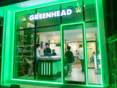 Exterior of Greenhead Nimman cannabis shop in Nimmanhaeminda Road, Chiang Mai, with green neon trim.