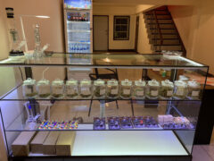 Inside Happy Cannabis dispensary, Chiang Mai, showcasing cannabis flower jars and smoking accessories.