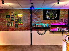 Interior of High Hemp cannabis shop in Kamphaeng Phet, Thailand, with brick walls, cannabis art, and smoking accessories.
