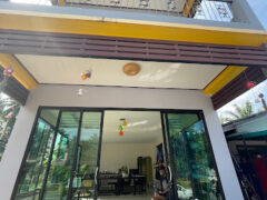 Exterior of Khanom Cannabis dispensary in Khanom District, Nakhon Si Thammarat, showing entrance with glass doors, and water bottles.