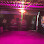 Pink and dark room with bright light overhead, possible stage lighting.