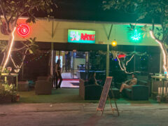 Popeyes Hua Hin cannabis shop exterior, Soi Mae Kep. Neon signs, including weed leaf, visible. Open late.