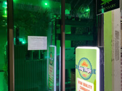 Exterior of SAY HIGH Dispensary, a cannabis shop in Hua Hin, Thailand, with green-tinted windows and signage.