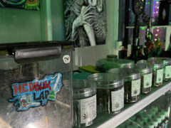 Interior of SPXCE HIGH Nontaburi dispensary, showing cannabis flower jars, accessories, and artistic decor in Nonthaburi, Thailand.