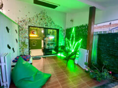 Exterior of Sudyod Ganja (The Green Room), a cannabis dispensary in Pak Nam Pran, Thailand. Neon leaf sign & green theme.