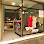 Clothing store window display with red dress visible.