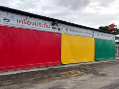 Exterior of shopfront in Bangkok, featuring red, yellow, and green panels.