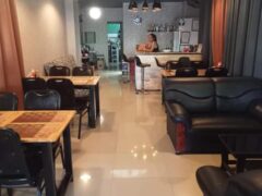 Interior of Horn Pub in Pattaya, Chonburi, showing seating areas, bar, and a TV screen, also serving cannabis-friendly meals.