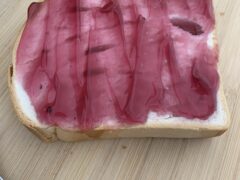 Toast with Jelly on Wooden Cutting Board with Tongs