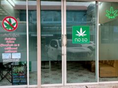 Exterior of Kor Chor cannabis shop in Thailand, with weed strains listed. Open sign.