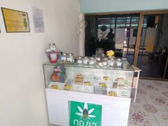 Kor Chor cannabis shop interior, showing many strains of weed, with product display and signs.