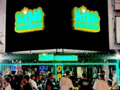 Exterior of King Cannabis in Pattaya City, Thailand, at night, with neon sign, people, and cannabis shop.