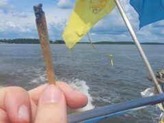 Burning pre-roll on a boat in Koh Phi Phi, Thailand, with Thai flags.