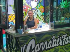Stone Face cannabis dispensary in Kai Bae, Koh Chang, Thailand. Staff at counter with graffiti and cannabis art.