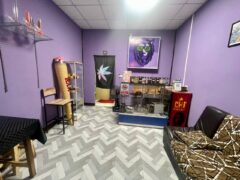Interior of SIAM HIGH WEED cannabis shop in Khon Kaen, Thailand, with cannabis accessories, dispensary display, purple walls.