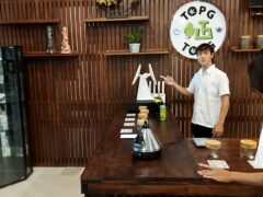 Inside Top Genetics cannabis shop in Chiang Mai, counter with cannabis flower and staff.