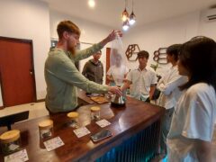 Top Genetics weed shop in Chiang Mai: staff member demonstrating product to customers.