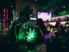 Inside LV Cannabis Boutique BKK, Sukhumvit 22, Bangkok: Cannabis shop featuring glowing marijuana leaf sign & smoking accessories.