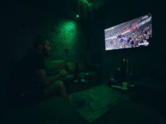 Inside Clouds cannabis shop, Phuket Old Town, with customer playing video game.