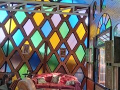 Interior of Chief Weed Dispensary in Mae Rim, Chiang Mai, showing colorful stained-glass windows, seating, and a patterned floor.