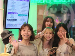 Four smiling women in front of Harmony Herb cannabis dispensary in Pattaya, Thailand.