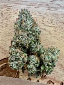 Cannabis flower bud on a wooden surface.