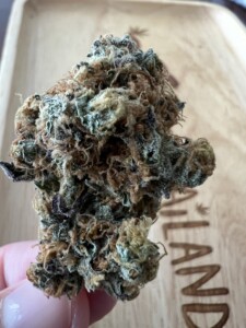 Close-up of a cannabis bud on a wooden tray.